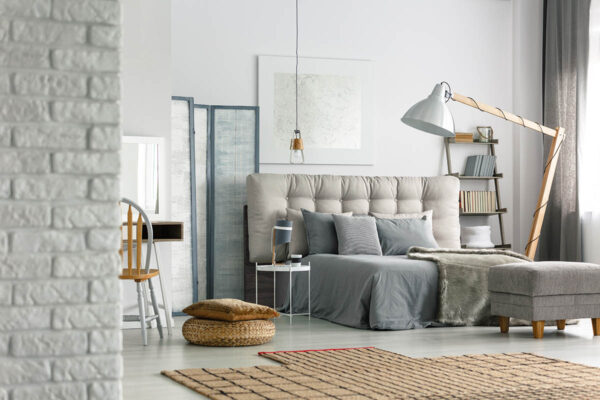 Cozy grey bedroom in modern loft with white brick wall